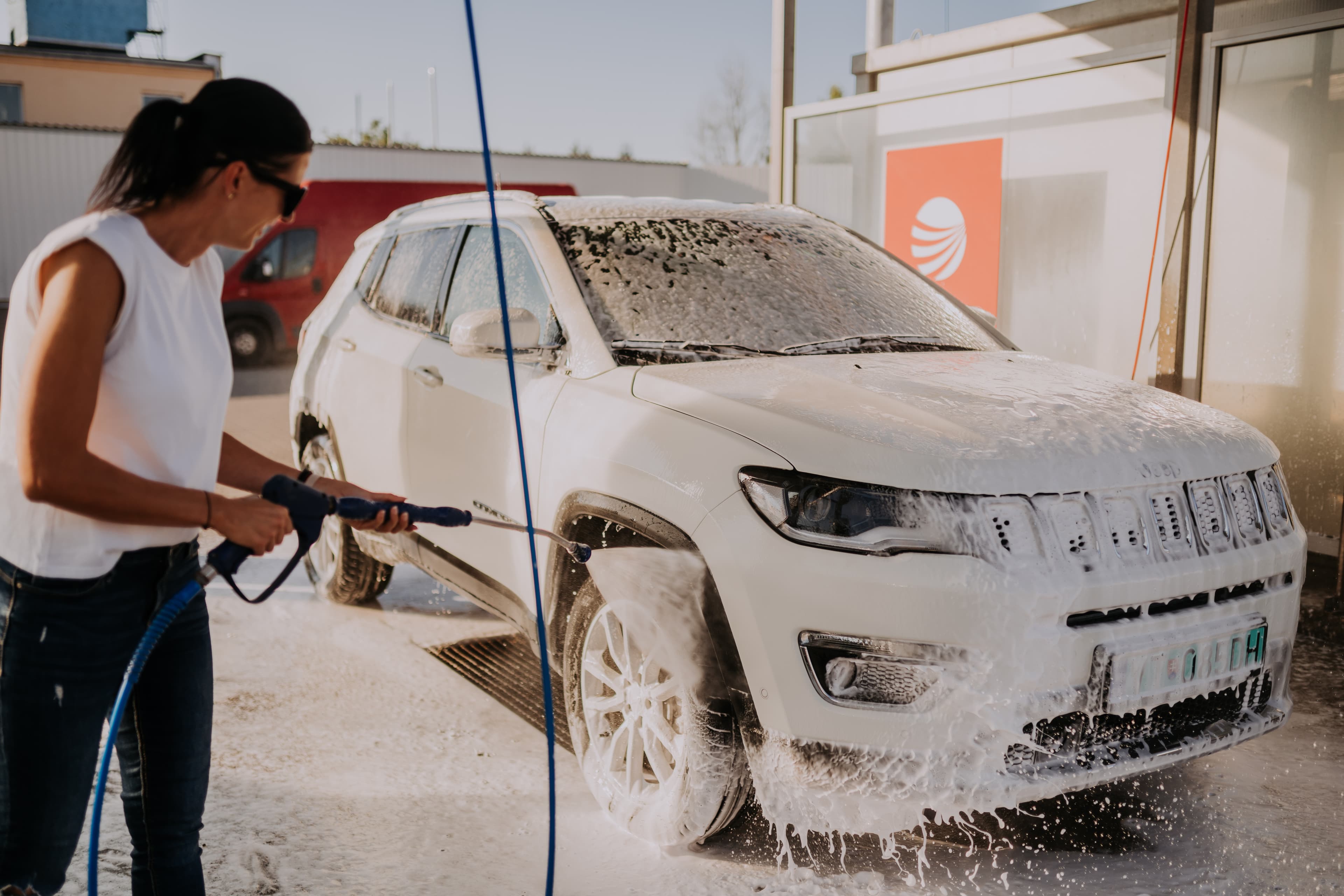Zakaznik umyva auto vysokotlakovou hadicou v samoobsluznej automyvarni EUROWASH